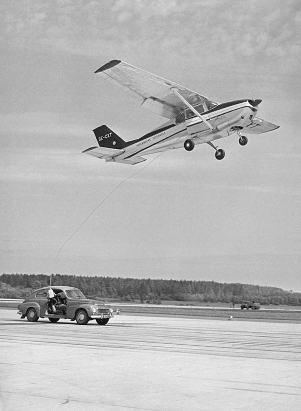 Tankning vid uthållighetsflygning över Skå-Edeby 1961-06-30 till 1961-07-02 då <br />J Hydén &amp; H Pettersson höll sig i luften 50 tim 25 min. <br />Bensin i 10 liters dunkar tas upp från bilen där Sven Hedman sköter leveransen.<br />Foto från SvD arkiv via Leif Hellström.