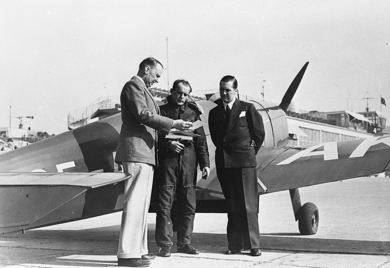 På bilden ses framför planet fr.v. Aeroklubbens generalsekreterare major C. Petersén, planets förare löjtn. M. Jacobsen och ingenjör Bertil Florman.