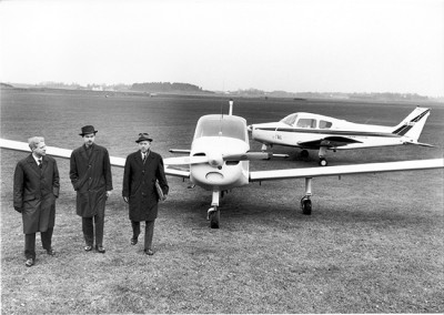 SE-EEY till höger på Saab-fältet 1963. Linköpings Flygklubb har skaffat två <br />Beechcraft 23 Musketeer, SE-EEK och SE-EEY. I förgrunden Bengt Olow, <br />Olof Esping och en ej identifierade man. <br />Foto: Per-Arne Nyhlén