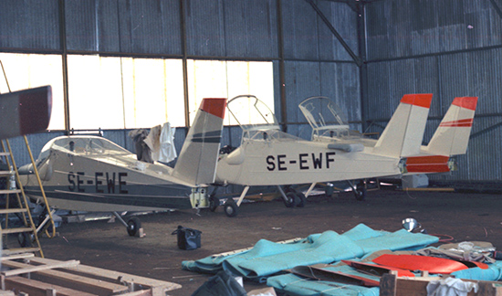 SE-EWE, SE-EWF samt ytterligare en MFI-9 i hangar i Gabon 1969. <br />Vingar och höjdroder ännu ej monterade. Foto ur Freddy Stenboms donerade samling.