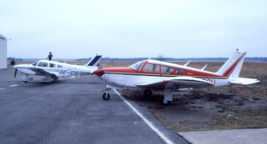 SE-FCU på Brandholmen, Nyköping 1981-12-14. Foto taget i samband med <br />att SE-FCU lämnades och efterföljaren SE-IDB som syns i bakgrunden hämtades <br />hos Nyge Aero AB.