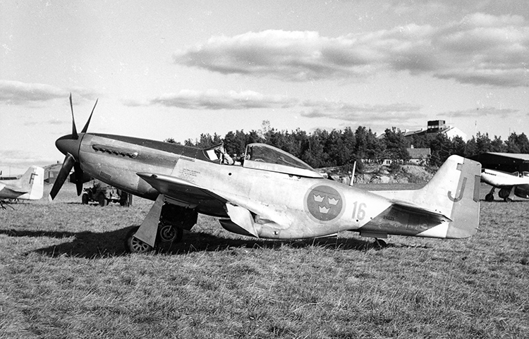 Här är 26023 märkt F 16 - J (blå). Foto enl notering på fotobaksida: Arne Frykholm. <br />Är platsen F 16 Uppsala? Ungefär när kan fotot vara taget?