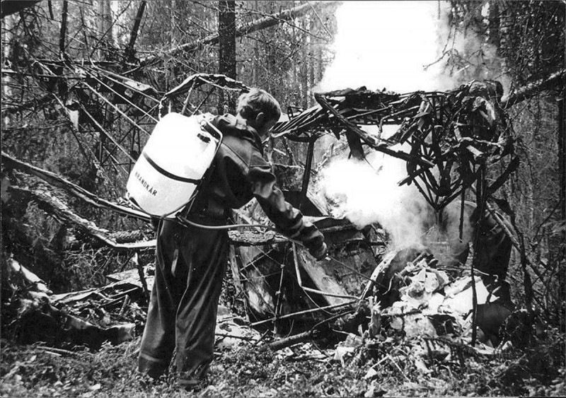 Brandman Toivo Roininen, Nyhammars brandkår eftersläcker. Flygplanet är sannolikt SE-EIE.<br />Foto via Leif Hellström.